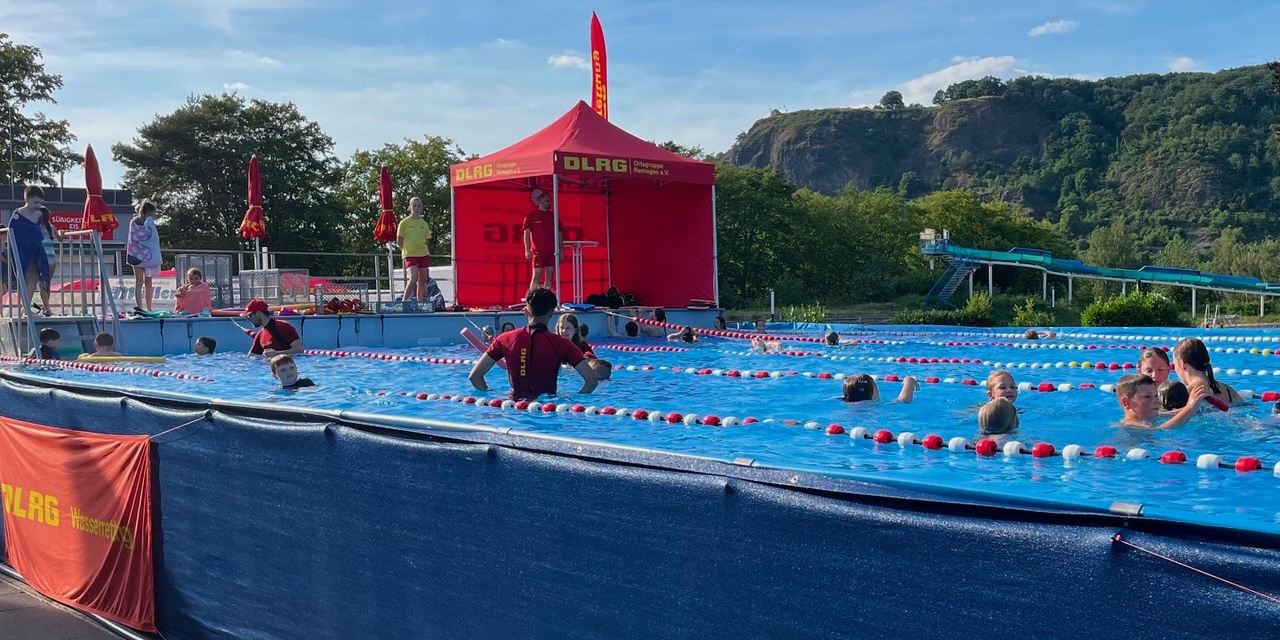 Blick über das mobile Schwimmbecken, in dem Kinder und Erwachsene schwimmen